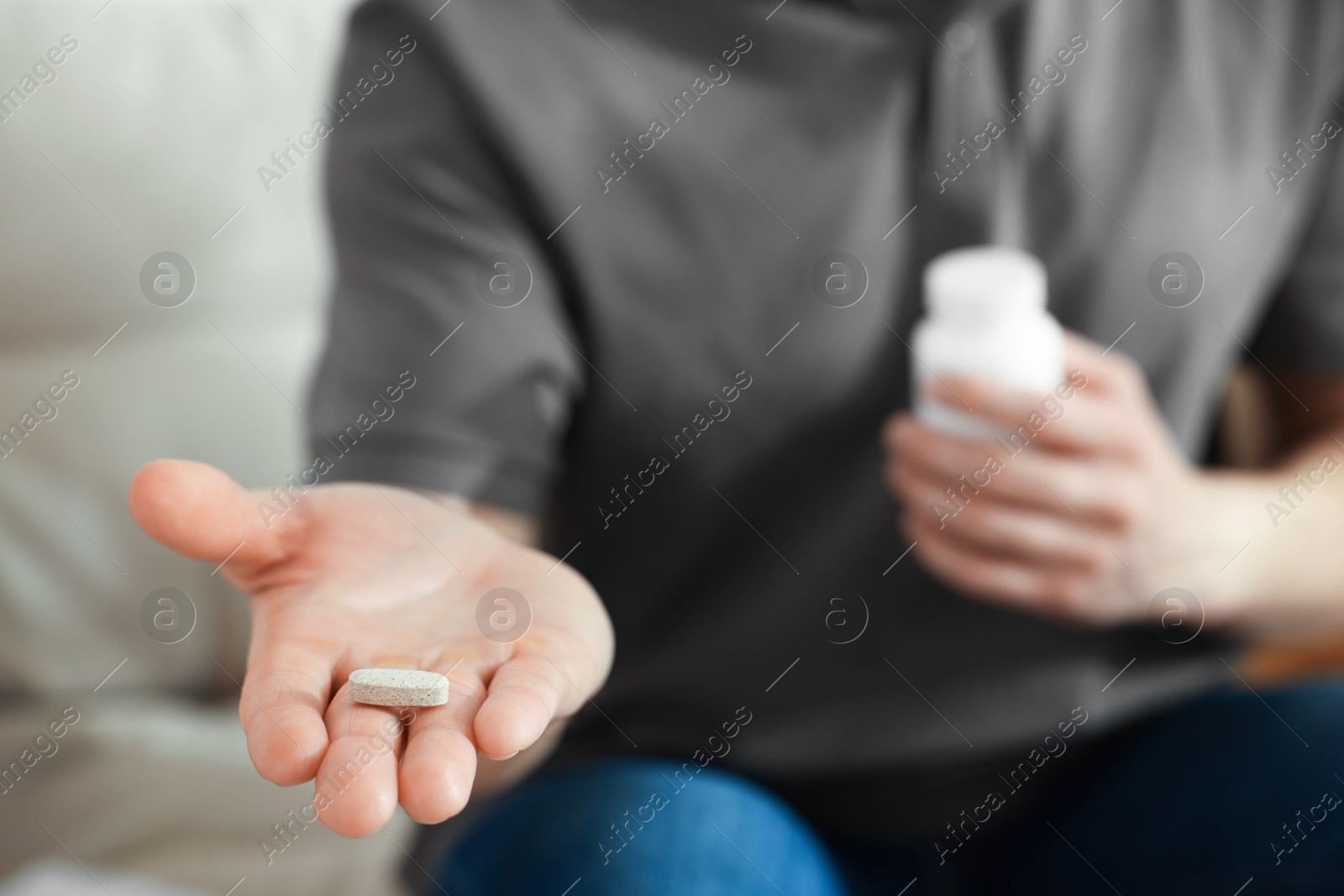 Photo of Man with pill at home, closeup on hand