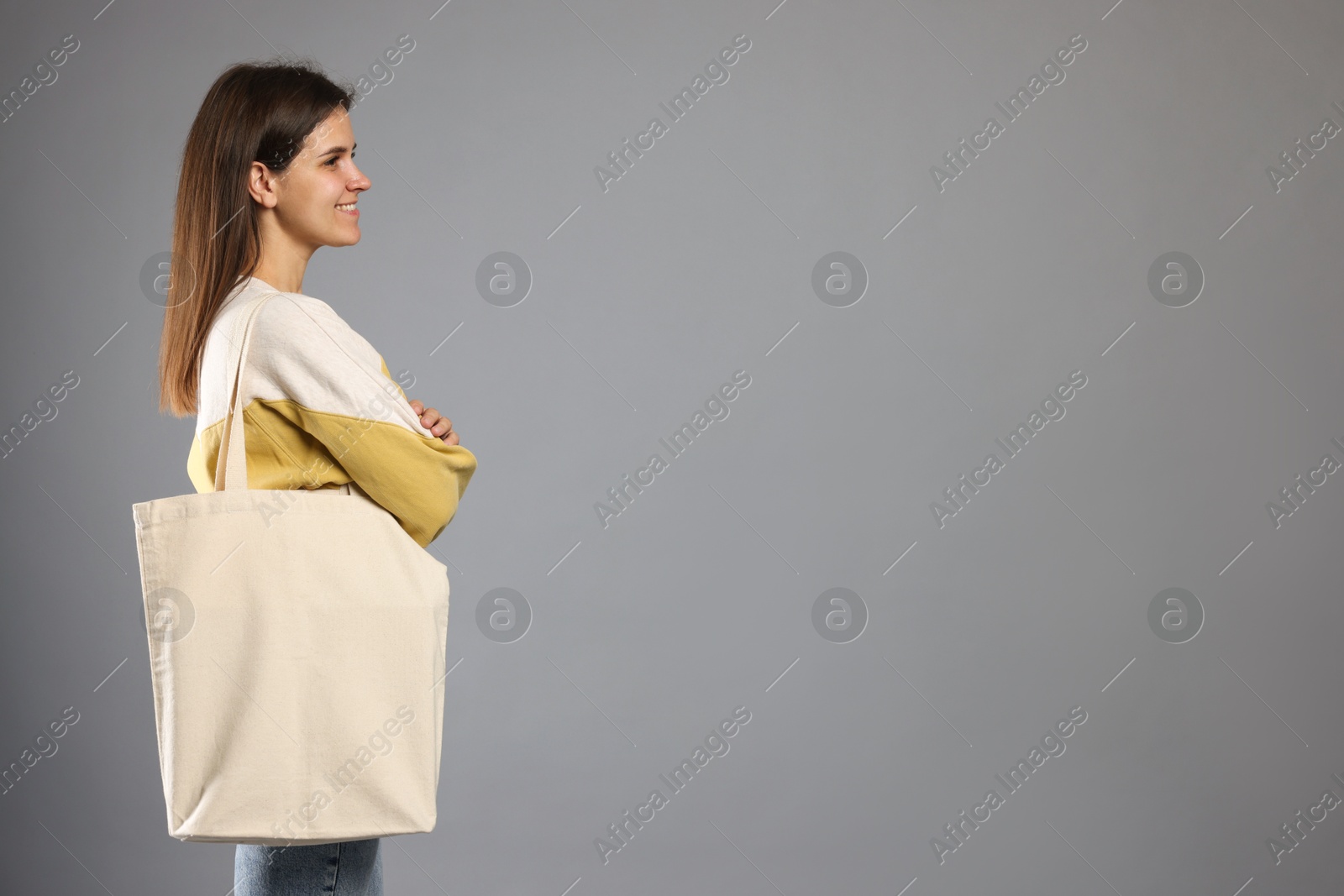 Photo of Woman with blank shopper bag on grey background. Mockup for design