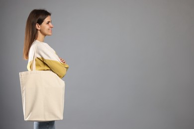 Photo of Woman with blank shopper bag on grey background. Mockup for design