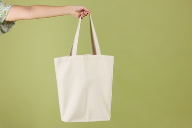 Photo of Woman with blank shopper bag on color background, closeup. Mockup for design