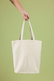 Photo of Woman with blank shopper bag on color background, closeup. Mockup for design