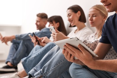 Group of people using different gadgets on floor indoors. Modern technology