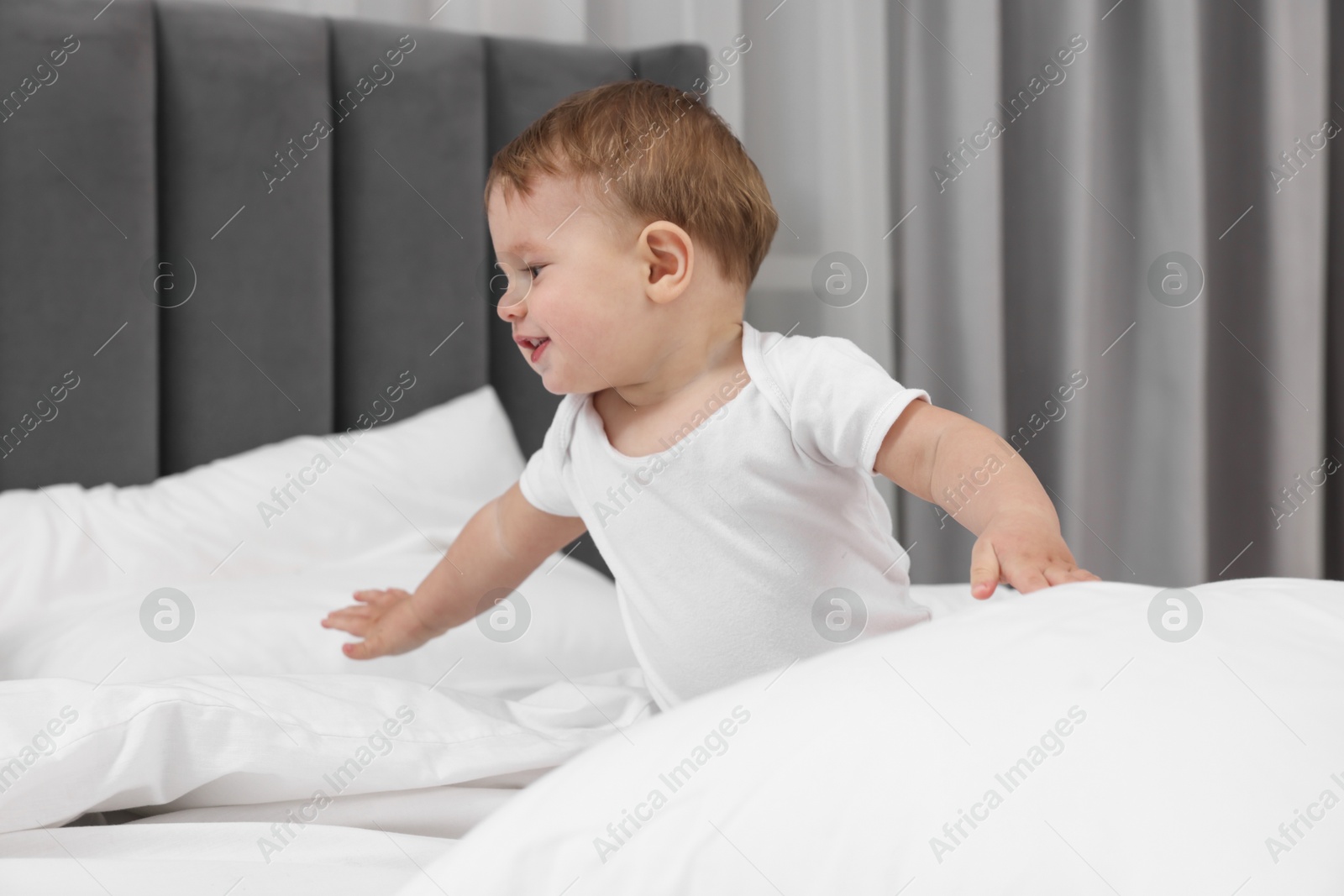 Photo of Funny little baby playing on bed at home