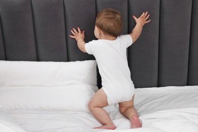 Photo of Funny little baby playing on bed at home