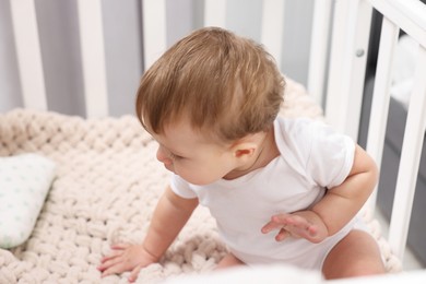 Photo of Cute little baby in crib at home