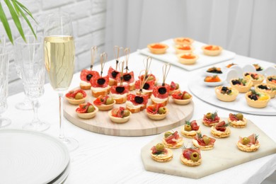 Photo of Many different tasty canapes on white wooden table