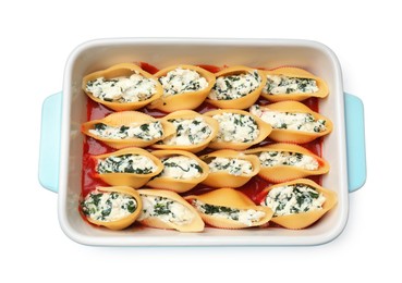 Photo of Delicious pasta with ricotta cheese, spinach and tomato sauce in baking dish isolated on white, top view