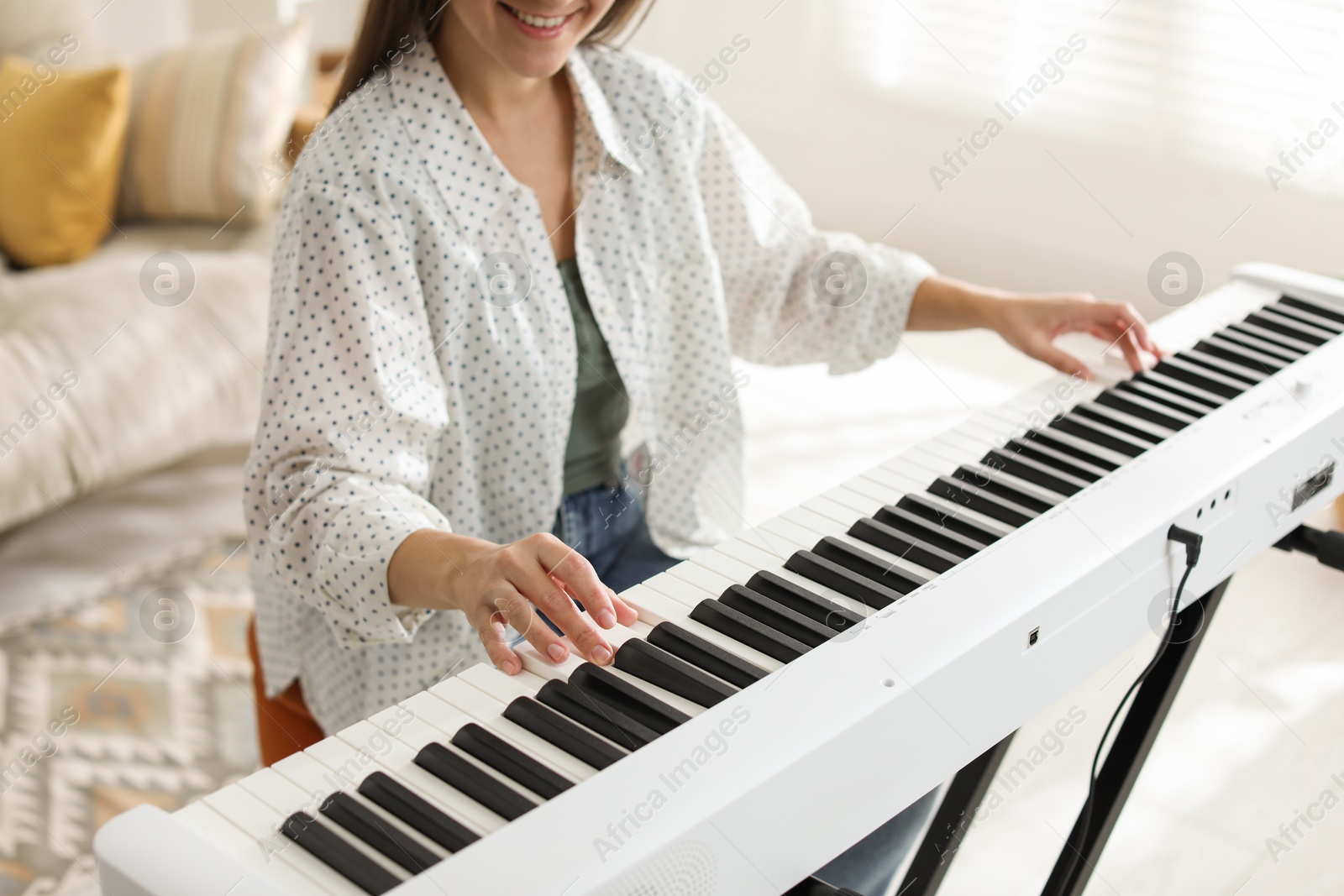 Photo of Smiling woman playing synthesizer at home, closeup