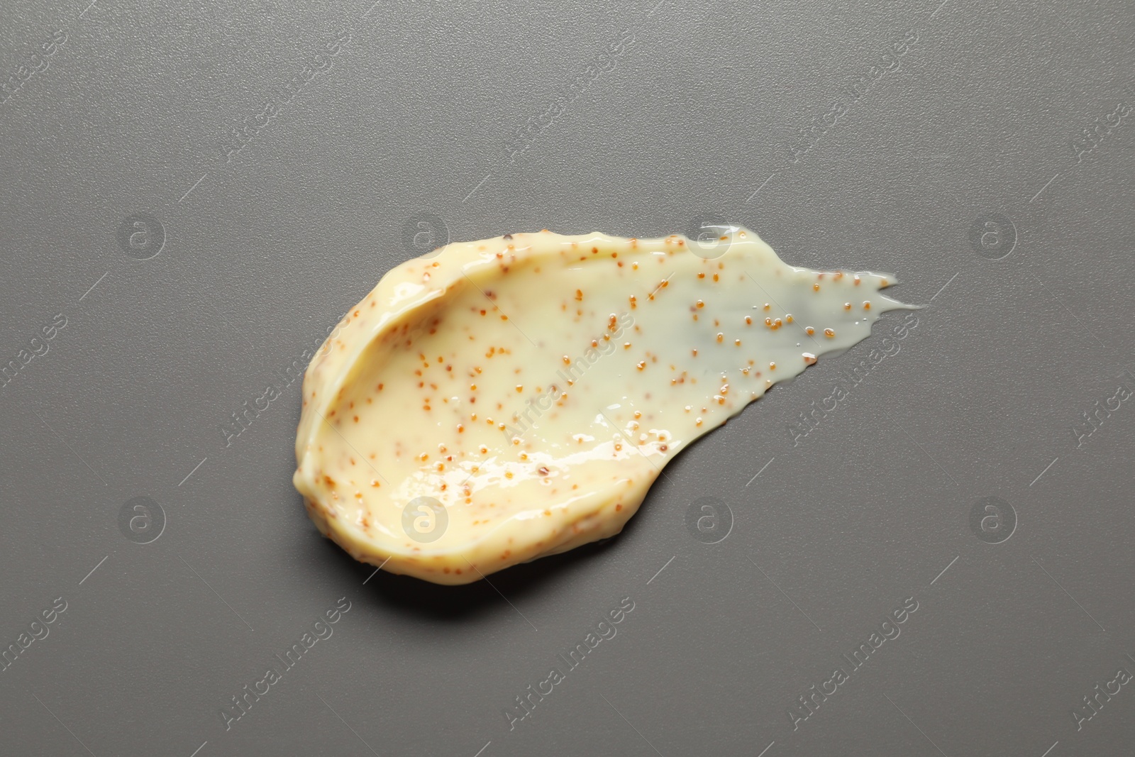 Photo of Smear of body scrub on grey background, top view