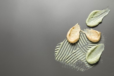 Photo of Samples of body scrubs on grey background, flat lay. Space for text