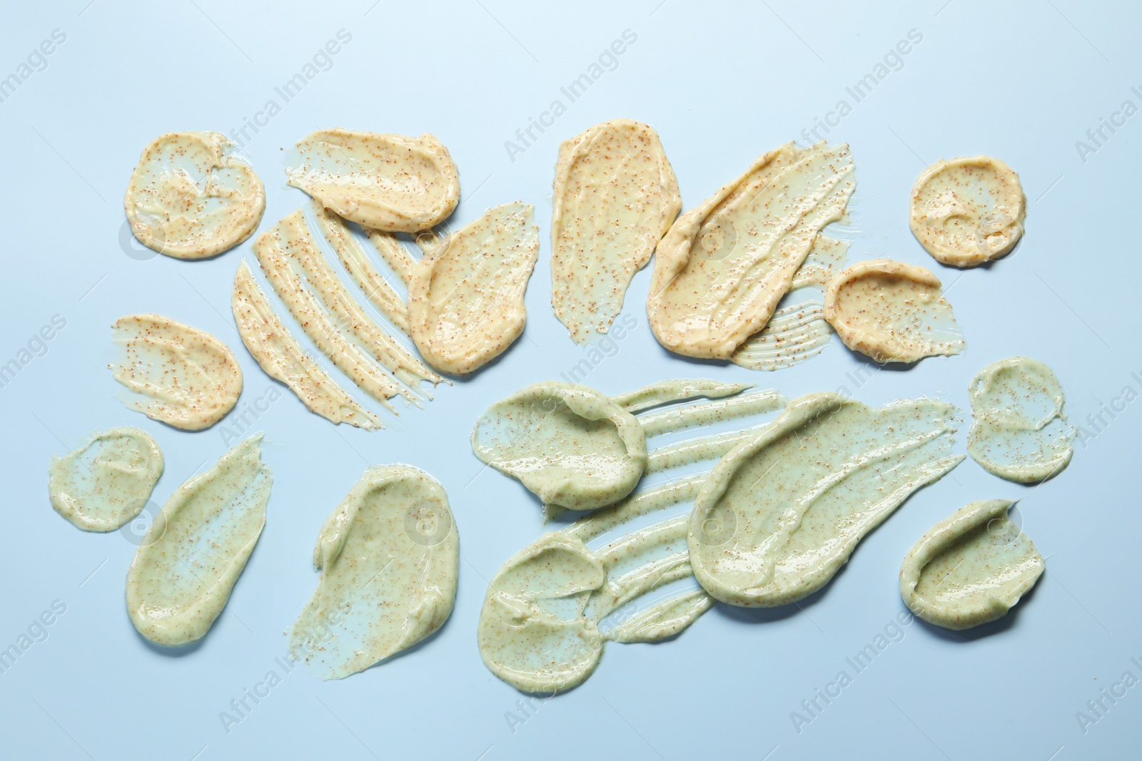 Photo of Samples of body scrubs on light background, flat lay