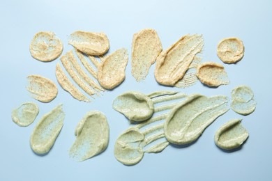 Photo of Samples of body scrubs on light background, flat lay