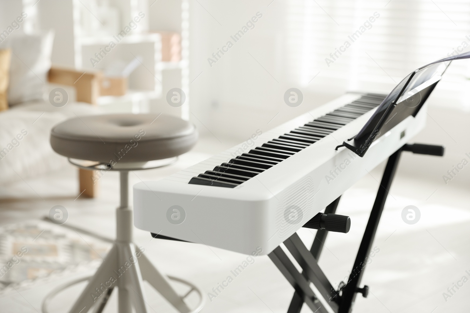 Photo of Synthesizer with music sheets and chair indoors