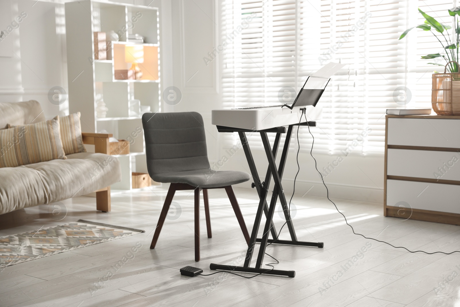 Photo of Synthesizer with music sheets and chair indoors