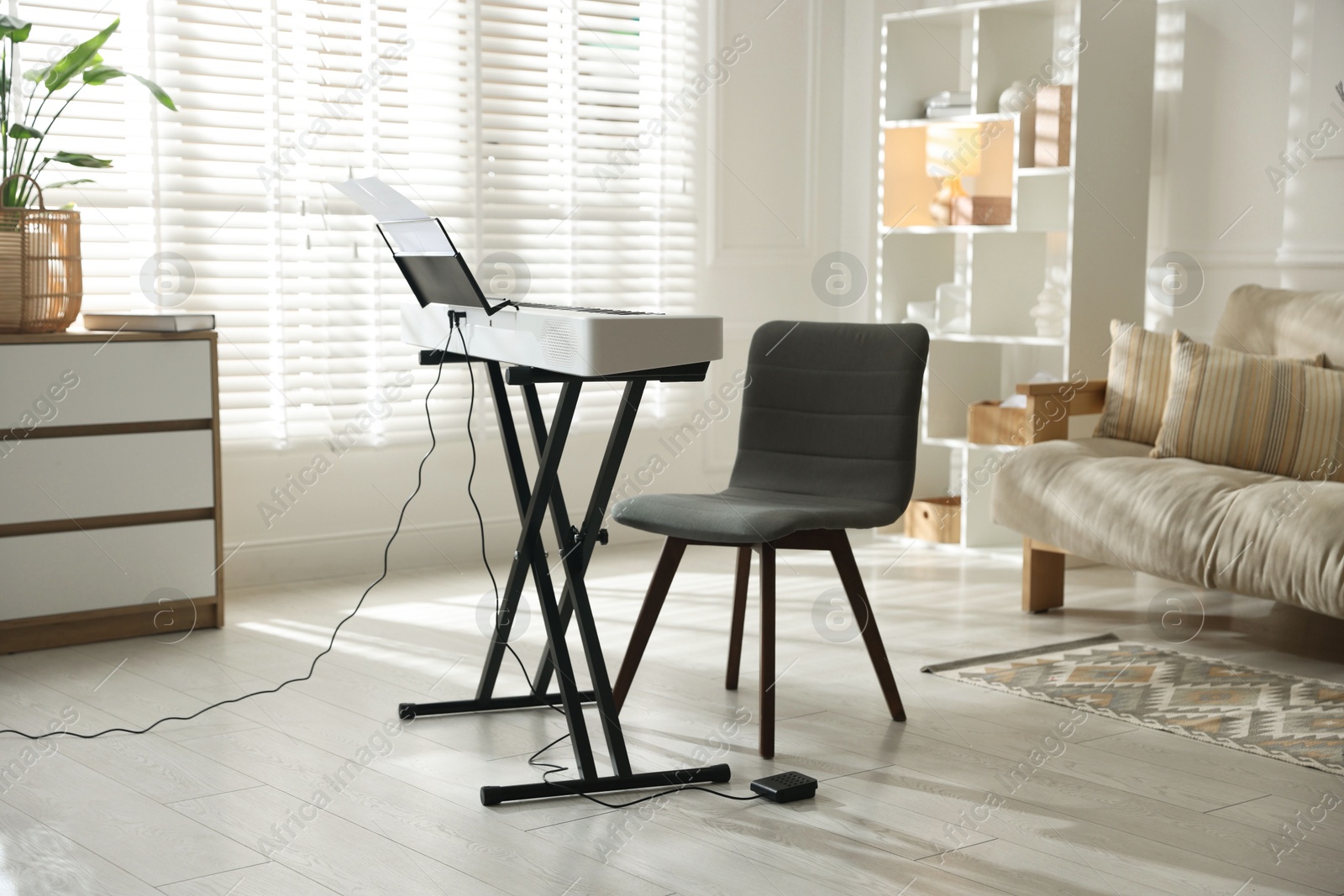 Photo of Synthesizer with music sheets and chair indoors