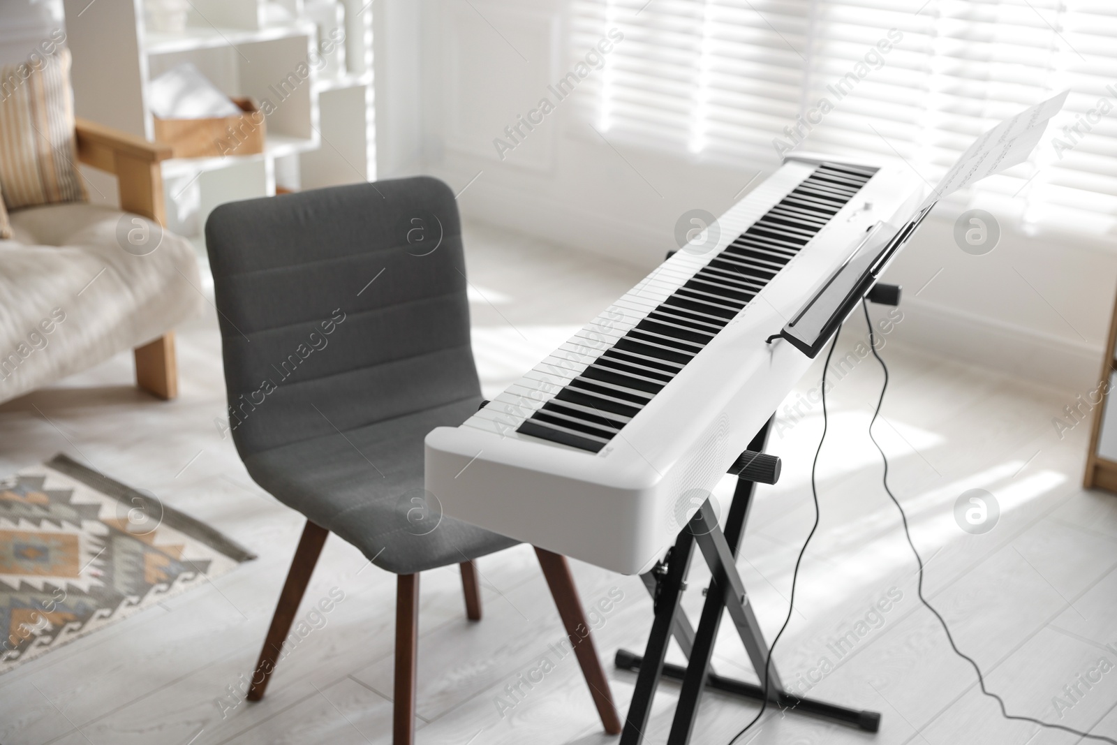 Photo of Synthesizer with music sheets and chair indoors