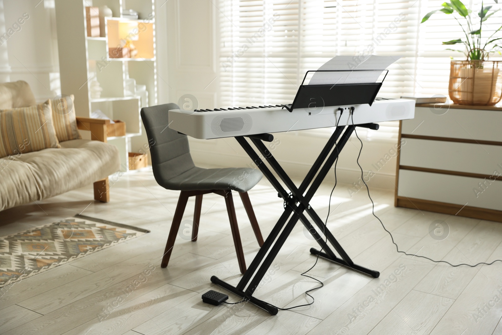 Photo of Synthesizer with music sheets and chair indoors