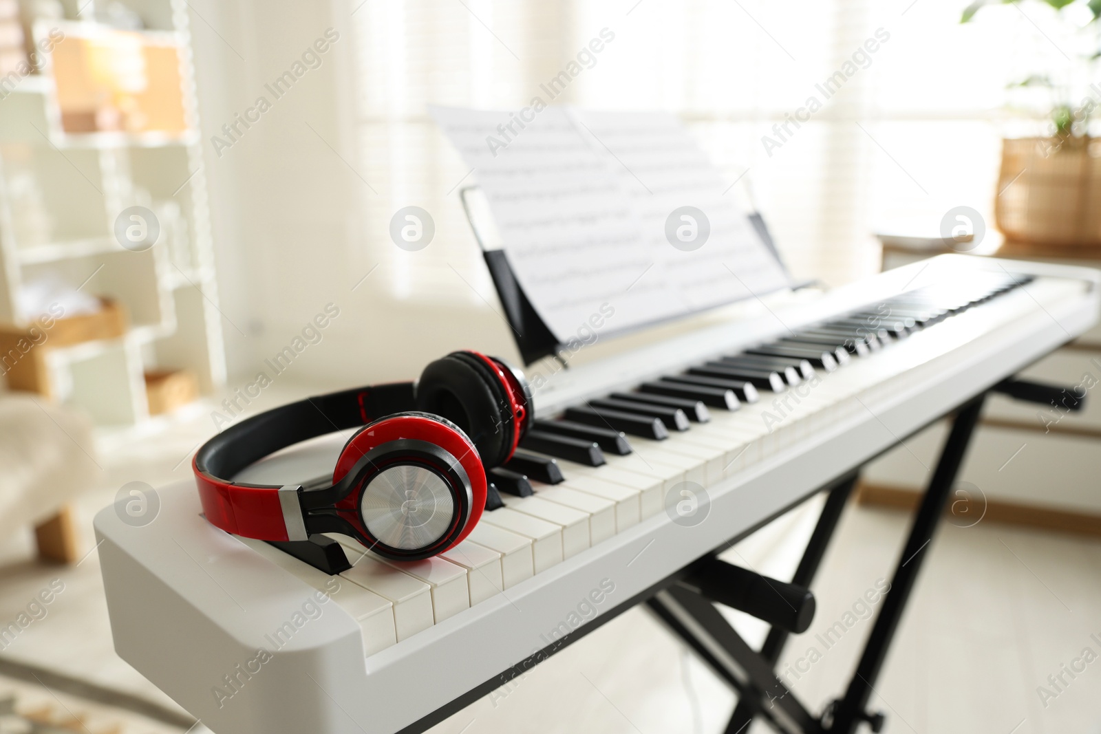 Photo of Synthesizer with music sheets and headphones indoors, closeup