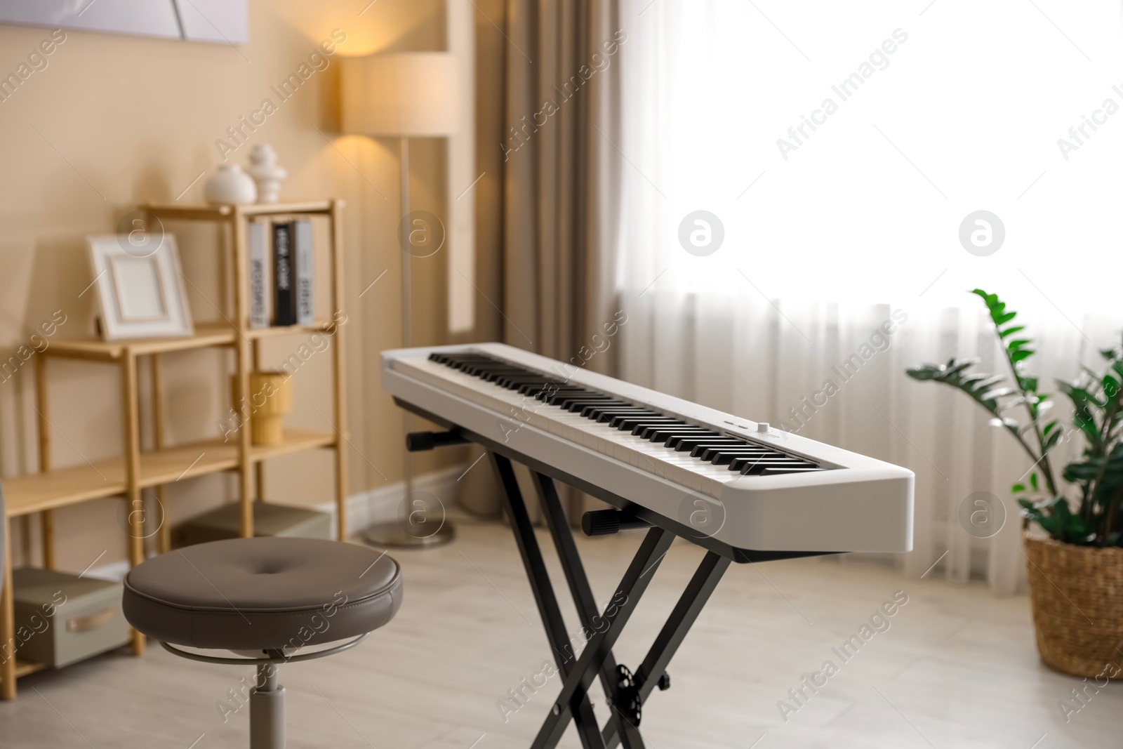 Photo of Synthesizer and stool indoors. Electronic musical instrument