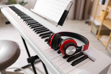 Photo of Synthesizer with music sheet and headphones indoors, closeup