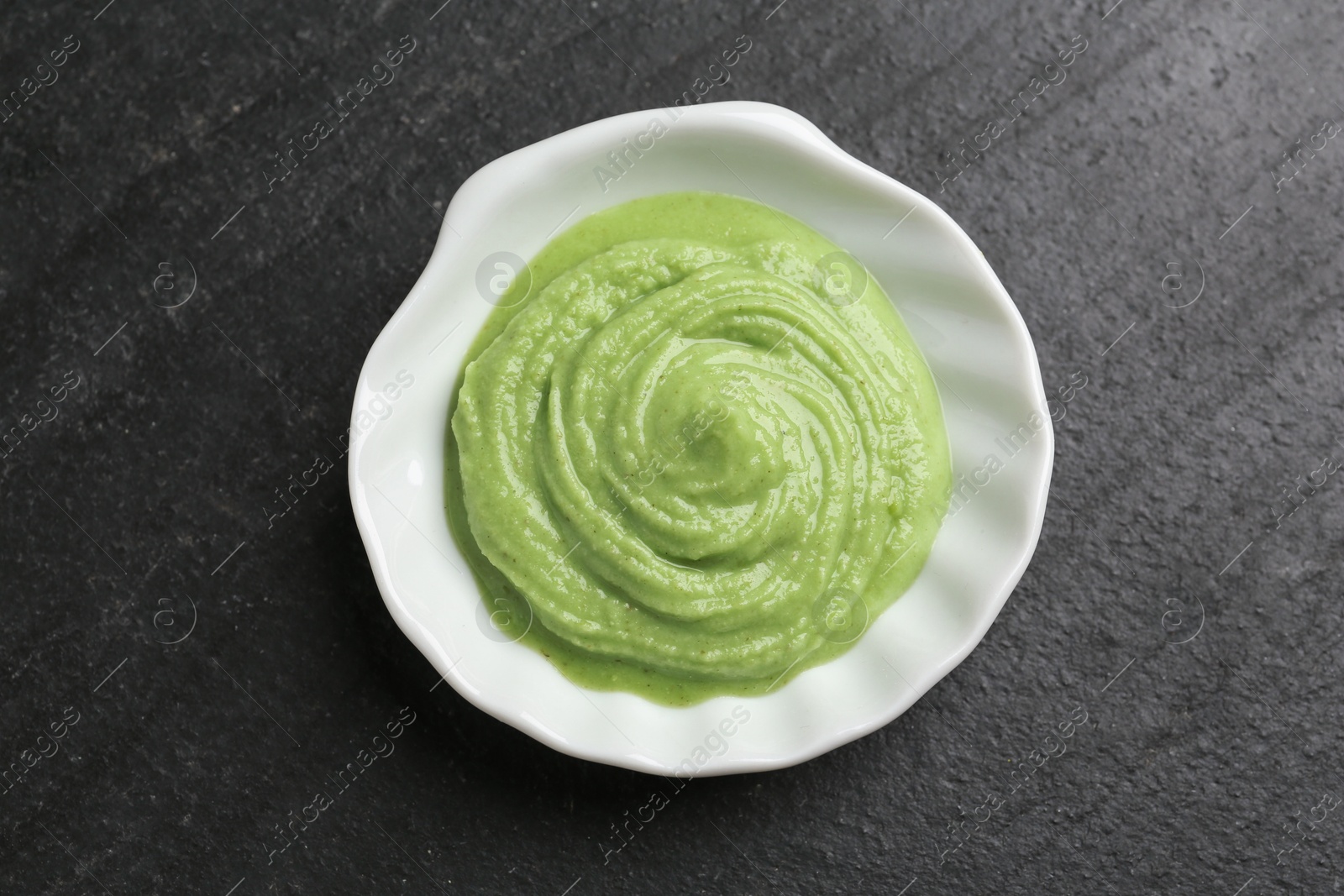 Photo of Hot wasabi paste on dark textured table, top view