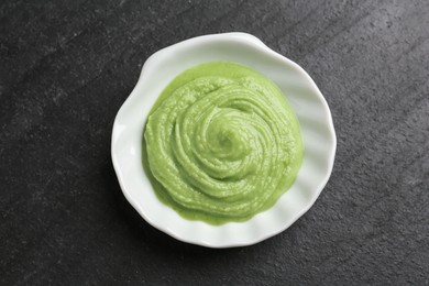 Photo of Hot wasabi paste on dark textured table, top view