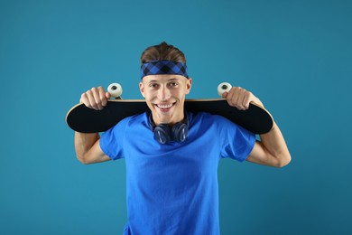 Photo of Happy man with skateboard on light blue background