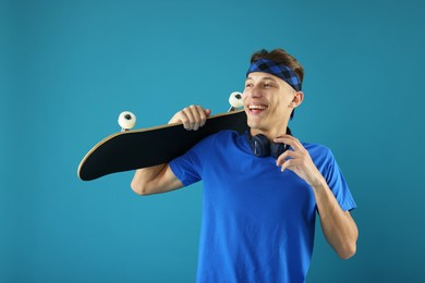 Photo of Happy man with skateboard on light blue background