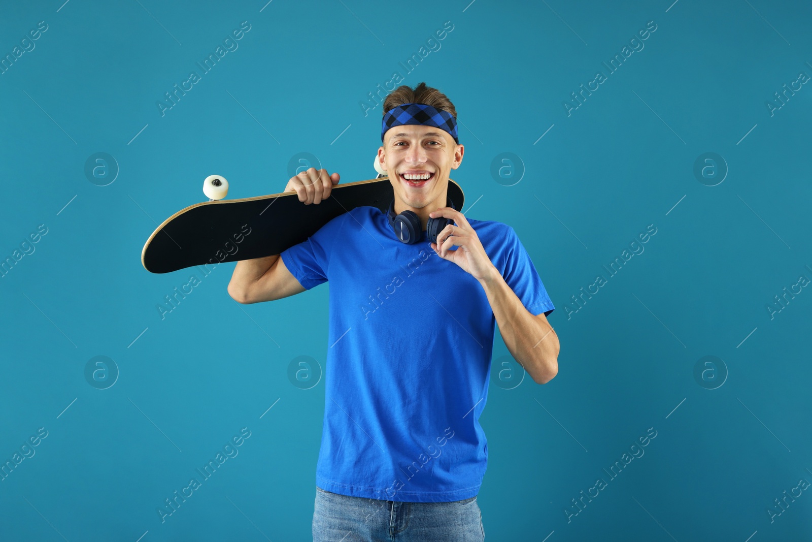 Photo of Happy man with skateboard on light blue background