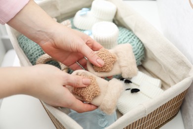 Photo of Woman with baby socks at home, closeup