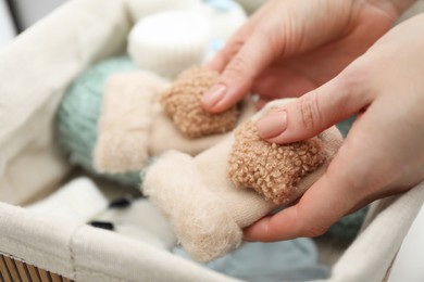 Photo of Woman with baby socks at home, closeup