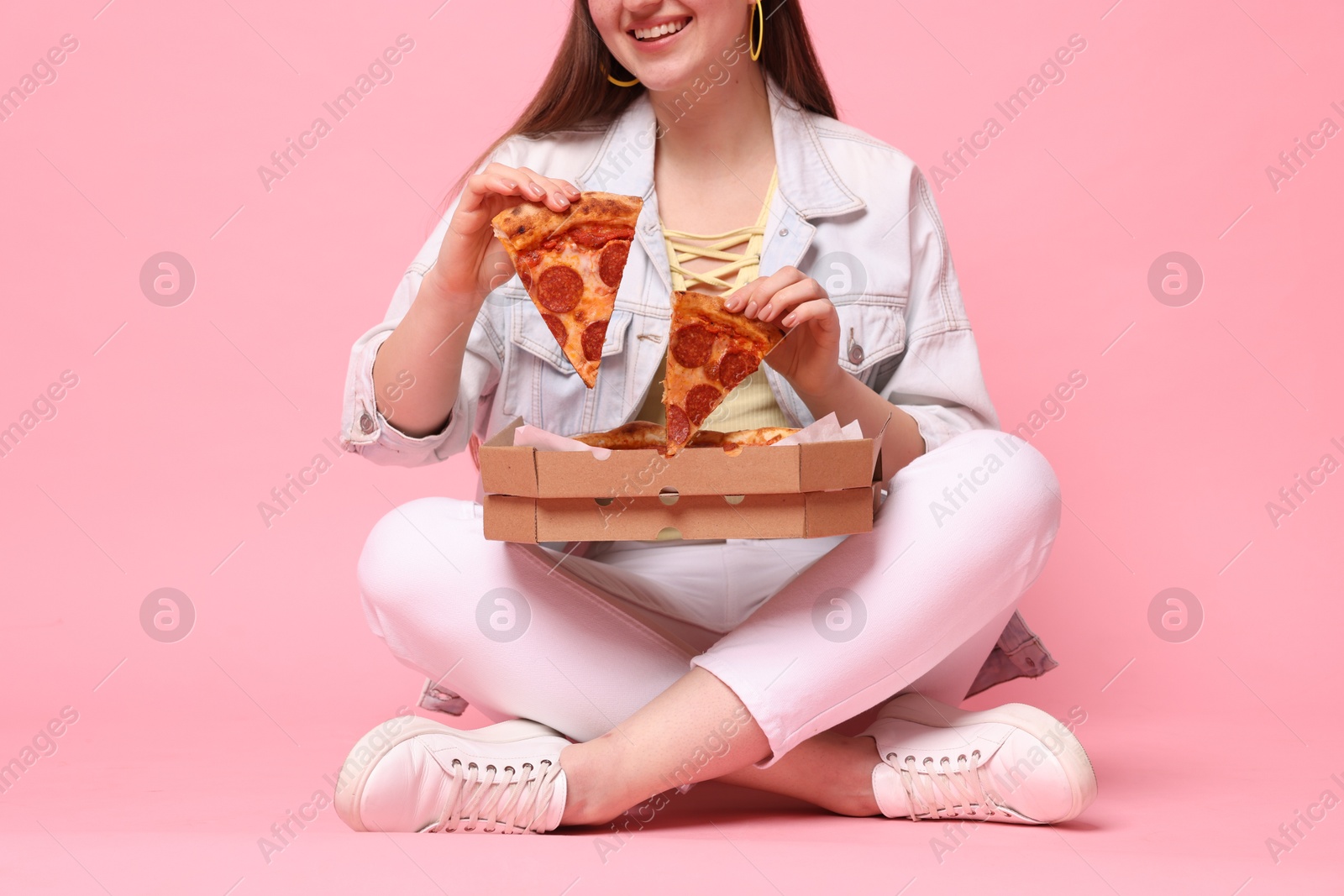 Photo of Woman with delicious pizza on pink background, closeup