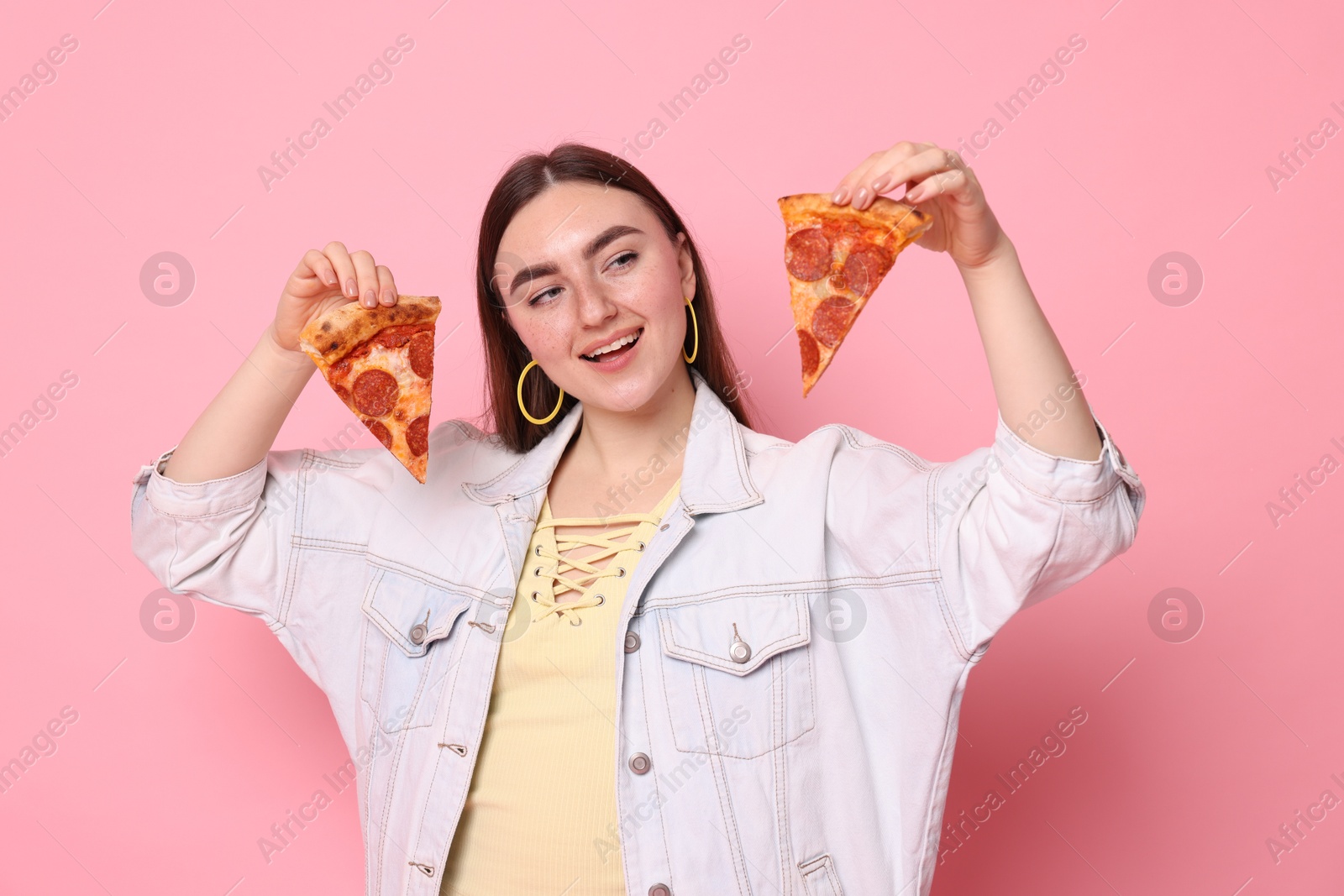 Photo of Beautiful woman with delicious pizza on pink background