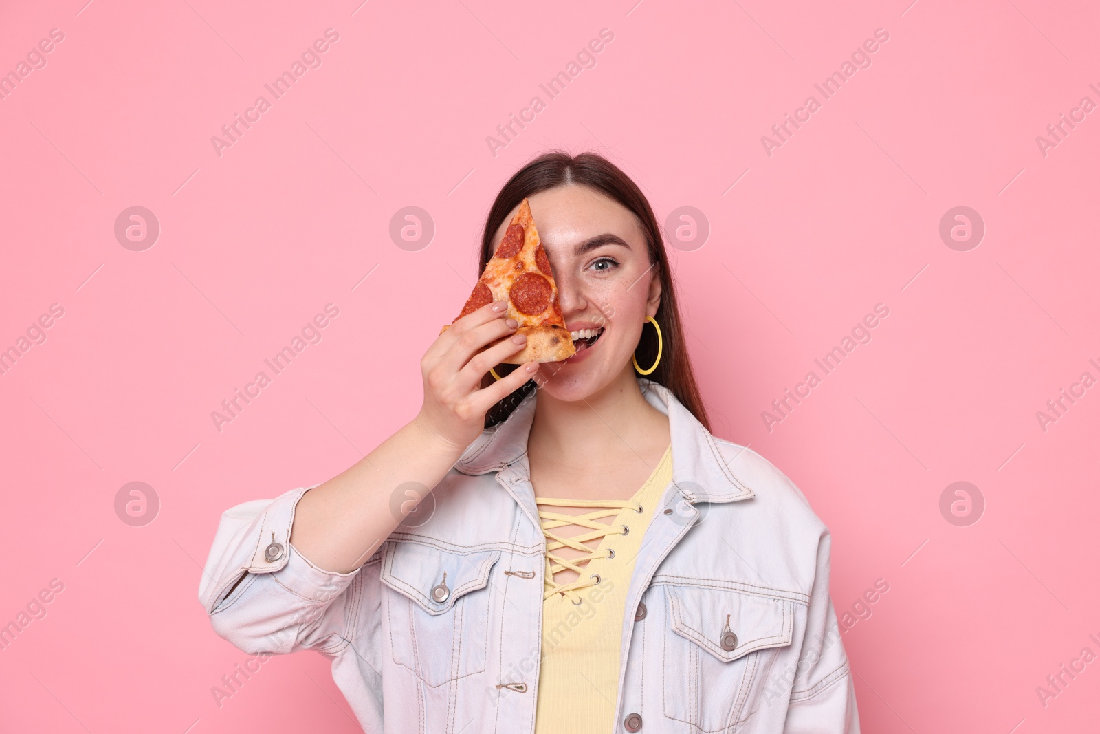 Photo of Beautiful woman with delicious pizza on pink background,