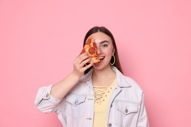 Beautiful woman with delicious pizza on pink background,