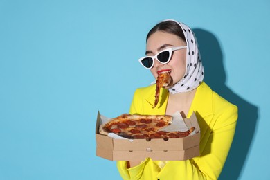 Photo of Stylish woman with delicious pizza on light blue background, space for text