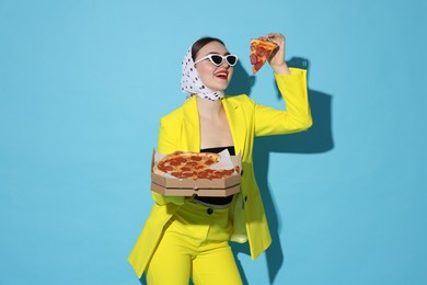 Photo of Stylish woman with delicious pizza on light blue background