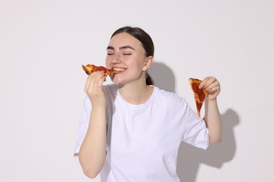 Photo of Beautiful woman eating pizza on white background