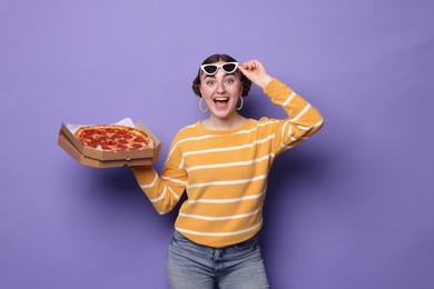 Photo of Beautiful woman with delicious pizza on violet background