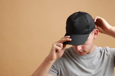 Photo of Man in stylish baseball cap on beige background. Mockup for design