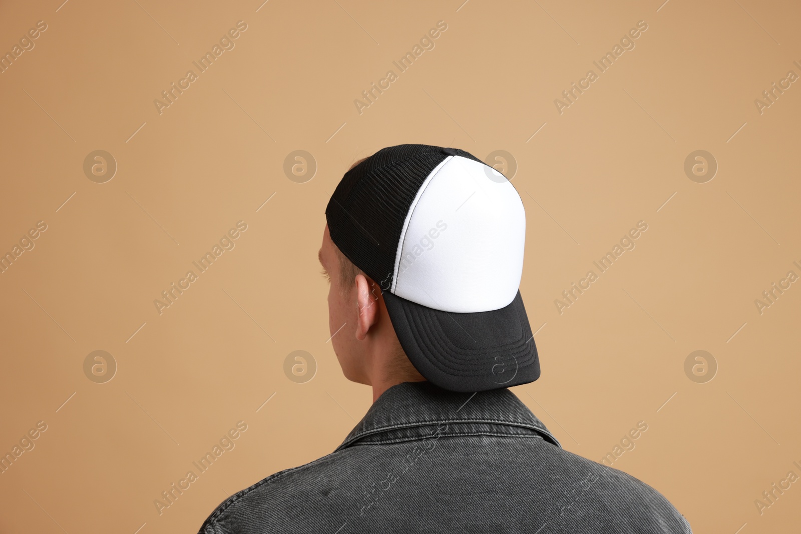 Photo of Man in stylish baseball cap on beige background, back view. Mockup for design