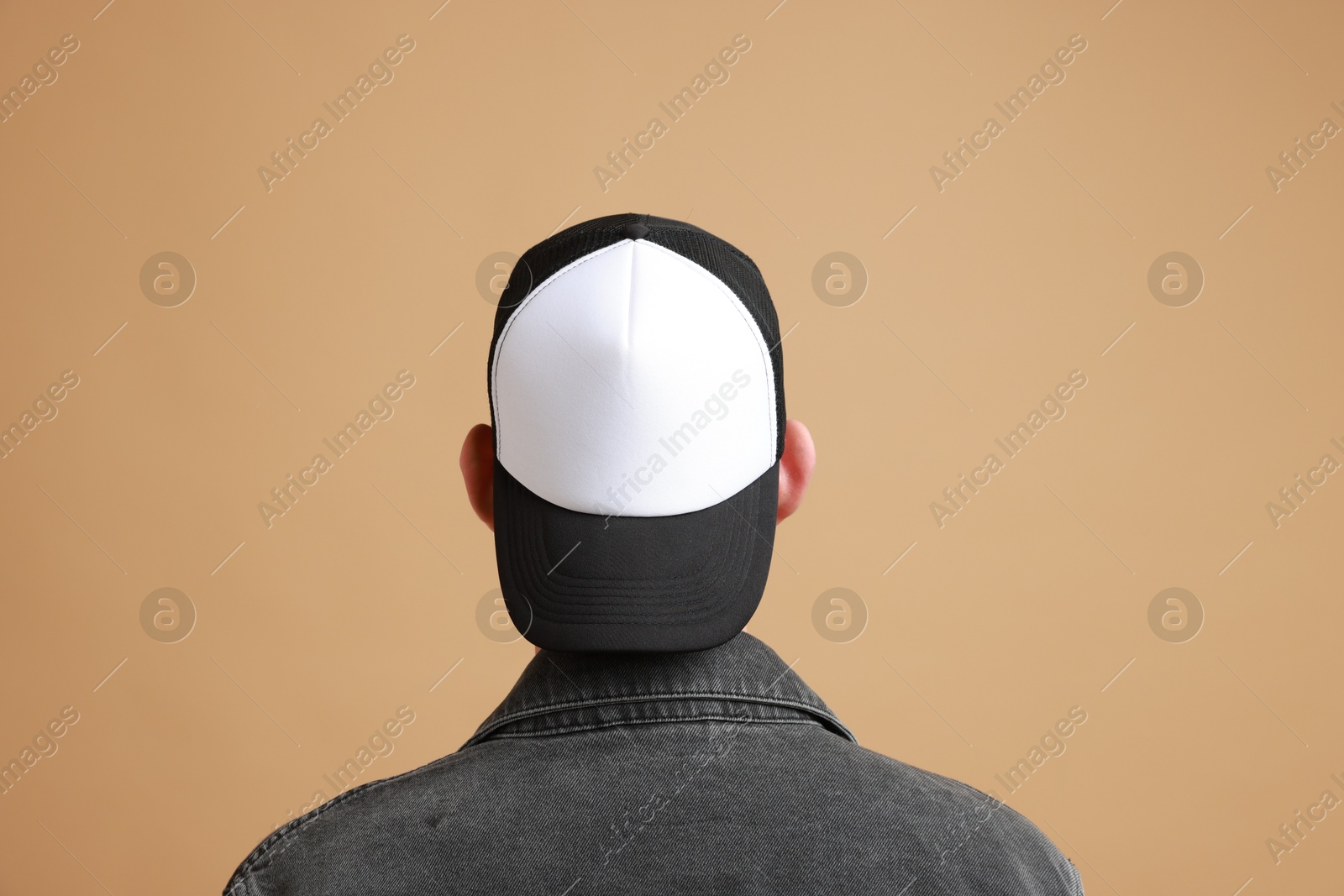 Photo of Man in stylish baseball cap on beige background, back view. Mockup for design