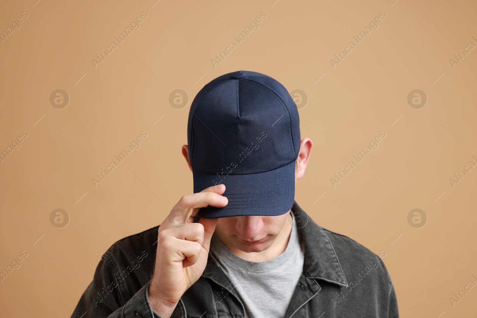 Photo of Man in stylish baseball cap on beige background. Mockup for design