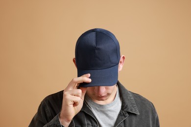 Photo of Man in stylish baseball cap on beige background. Mockup for design