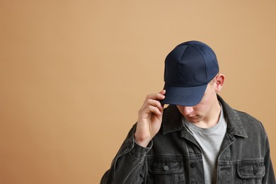 Photo of Man in stylish baseball cap on beige background. Mockup for design