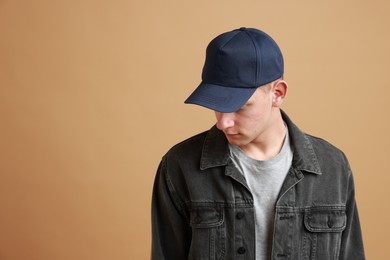 Man in stylish baseball cap on beige background. Mockup for design