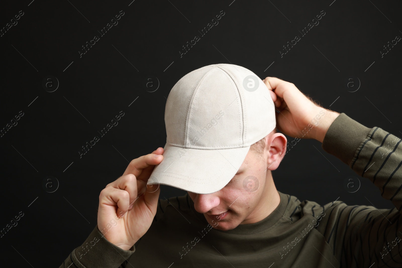 Photo of Man in stylish baseball cap on black background. Mockup for design