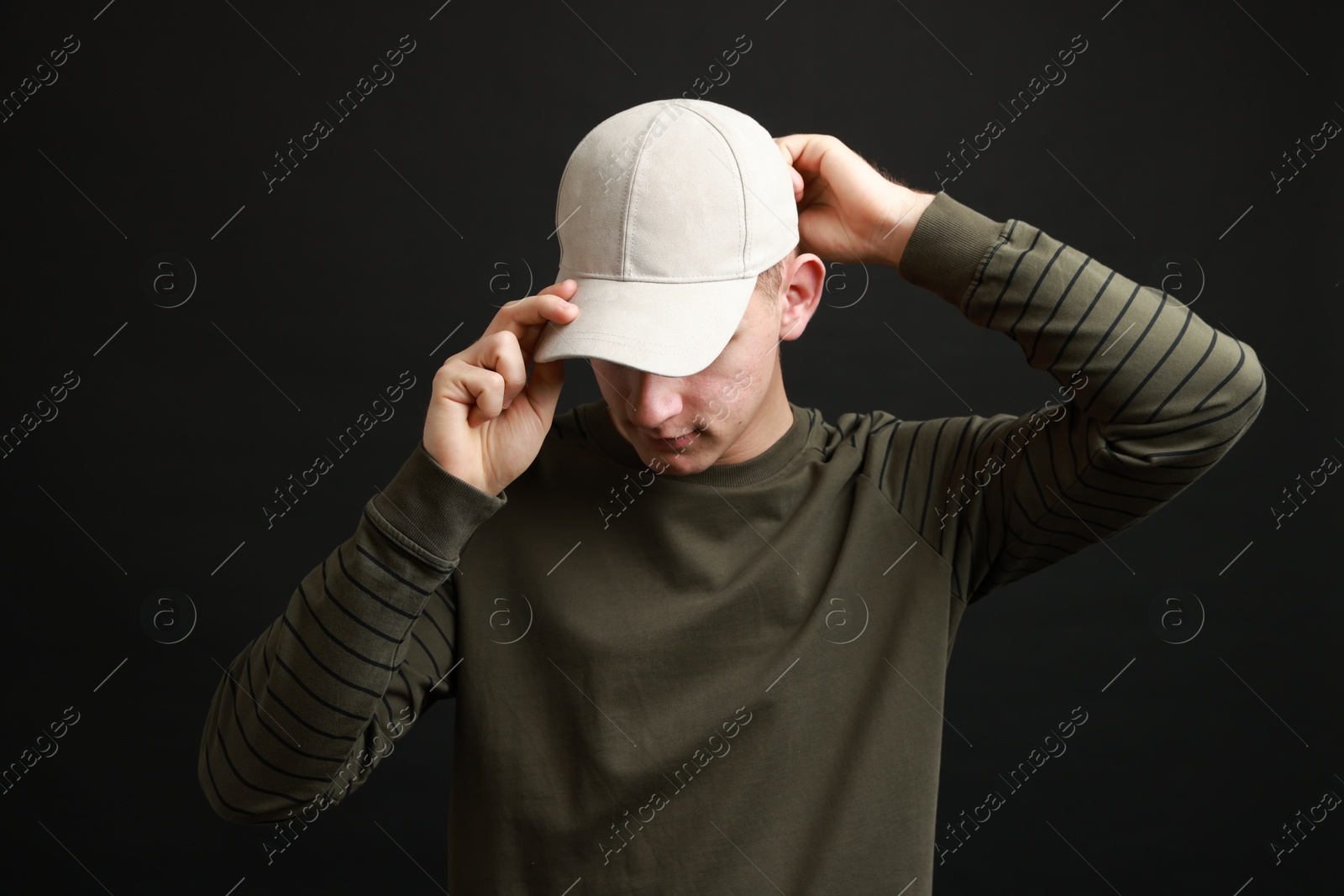 Photo of Man in stylish baseball cap on black background. Mockup for design