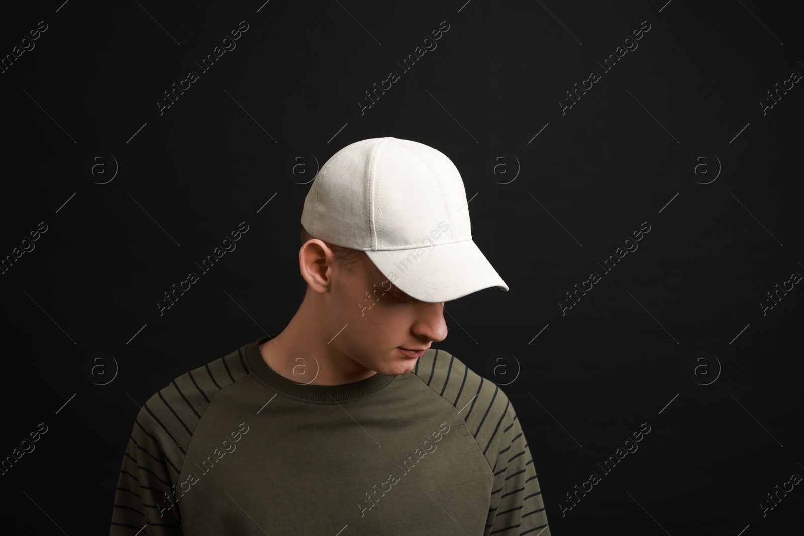 Photo of Man in stylish baseball cap on black background. Mockup for design