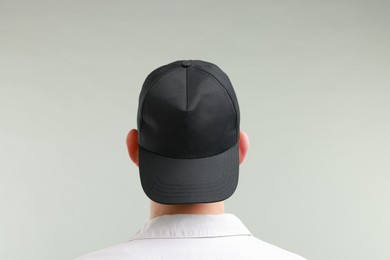 Photo of Man in stylish baseball cap on light grey background, back view. Mockup for design